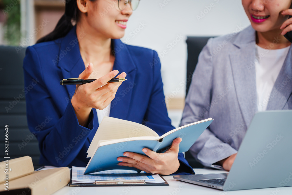 Two Asian businesswomen collaborate on stock market strategies and financial services, exchanging comments and suggestions on loan applications and investment opportunities. Two Asian businesswomen collaborate on stock market strategies and financial services, exchanging comments and suggestions on loan applications and investment opportunities.
