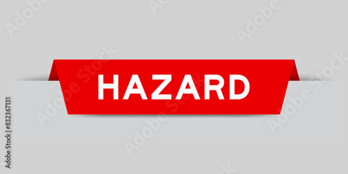 Red color inserted label with word hazard on gray background