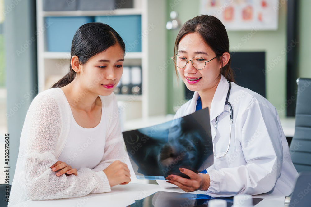Asian female doctor specializing in psychiatry works at her desk, providing psychotherapy, diagnosis, treatment, and counseling to psychiatric patients, utilizing x-ray films for assessments. Asian female doctor specializing in psychiatry works at her desk, providing psychotherapy, diagnosis, treatment, and counseling to psychiatric patients, utilizing x-ray films for assessments.