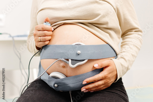 Fototapeta Woman pregnant checking fetal heart beat by fetal monitoring