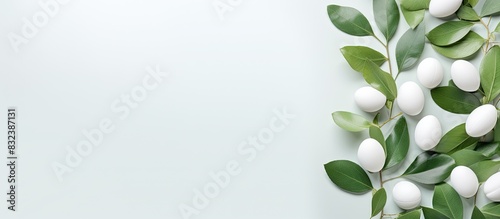 Easter layout with white eggs and green leaves on pastel background Minimal Easter concept Spring nature composition Flat lay top view. copy space available