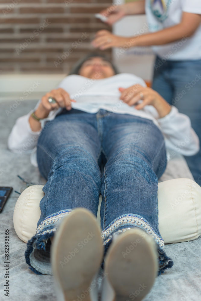 Fototapeta premium Woman lying on the couch waiting for acupuncture treatment. Vertical