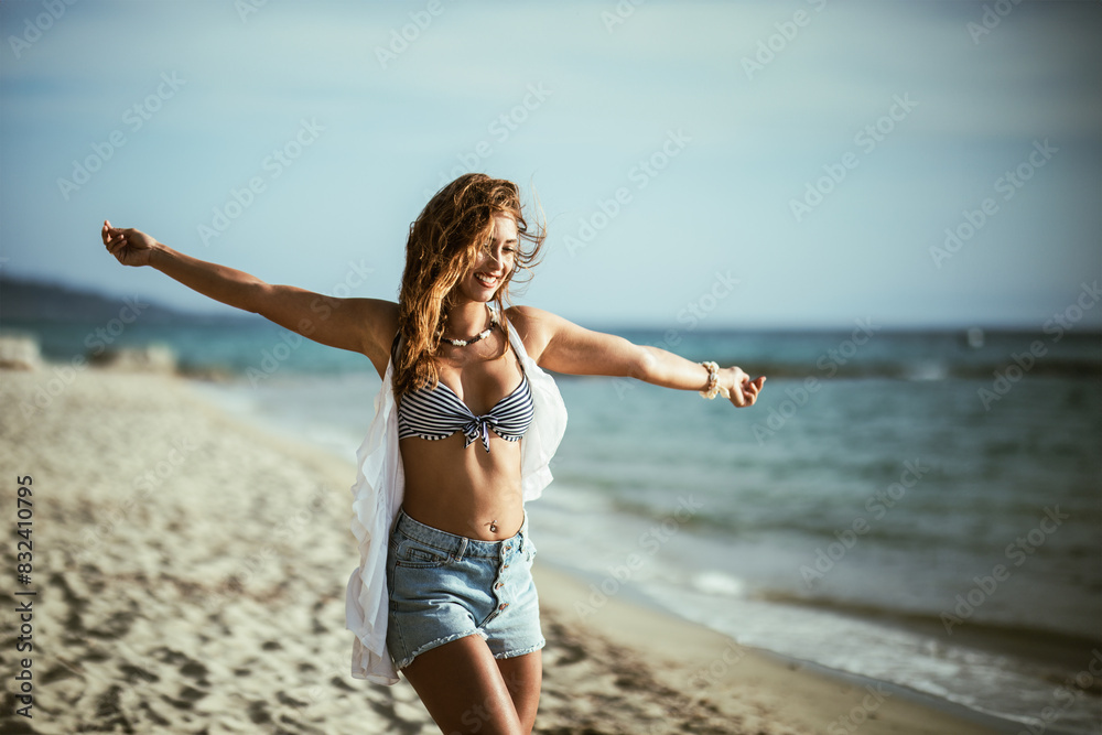 Naklejka premium Woman Dancing on a Sandy Beach