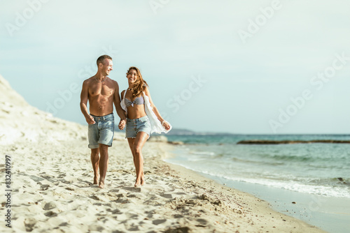 Man and Woman Walking on the Beach © milanmarkovic78