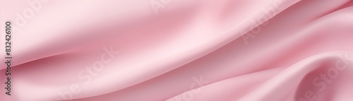 Smooth pink silk fabric with soft folds creating an elegant background, perfect for textiles and design projects.