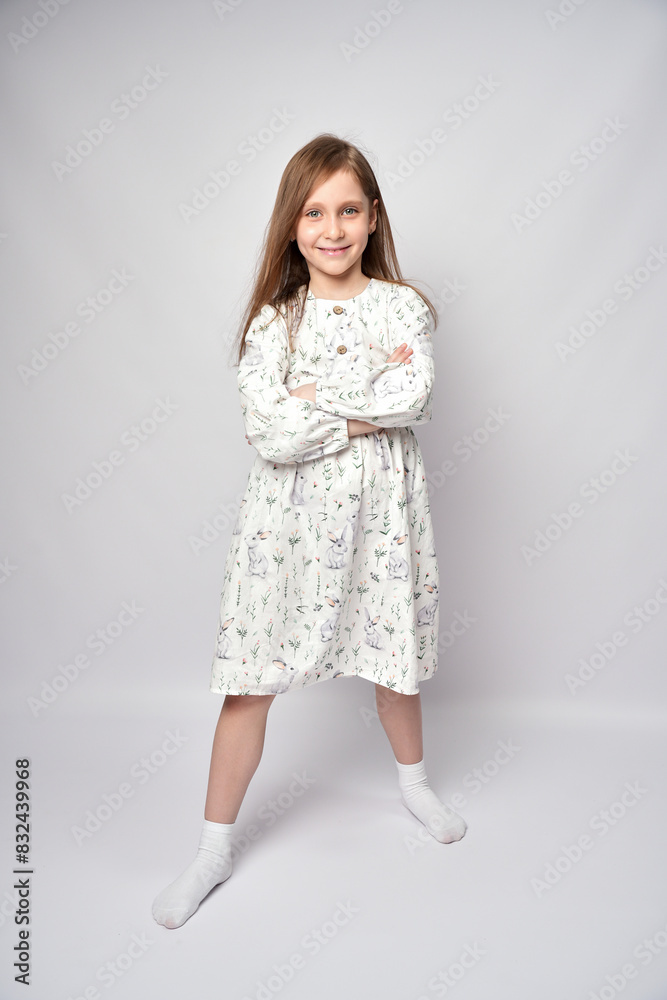 Full length portrait of a kid girl standing with crossed arms, white background Full length portrait of a kid girl standing with crossed arms, white background
