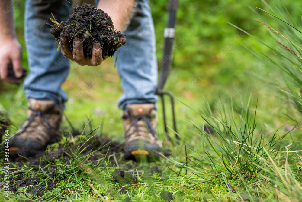 farmer wearing blue shirt and jeans, farmer holding soil, doing soil tests in a home laboratory. Looking at soil life and health farmer wearing blue shirt and jeans, farmer holding soil, doing soil tests in a home laboratory. Looking at soil life and health