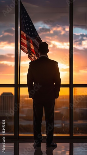 Executive silhouette against sunrise and flag, contemplating the day ahead in the corporate world