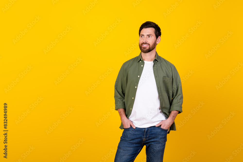 Photo of nice young man look empty space wear khaki shirt isolated on yellow color background