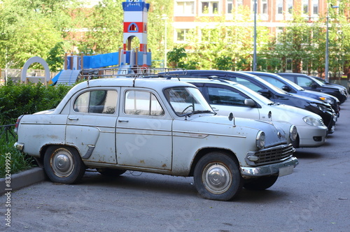 An old gray Soviet car stands in the courtyard of an apartment building, Badaeva Street, St. Petersburg, Russia, May 29, 2024 photo