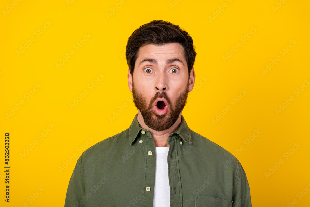 Obraz premium Photo of nice young man staring wear khaki shirt isolated on yellow color background