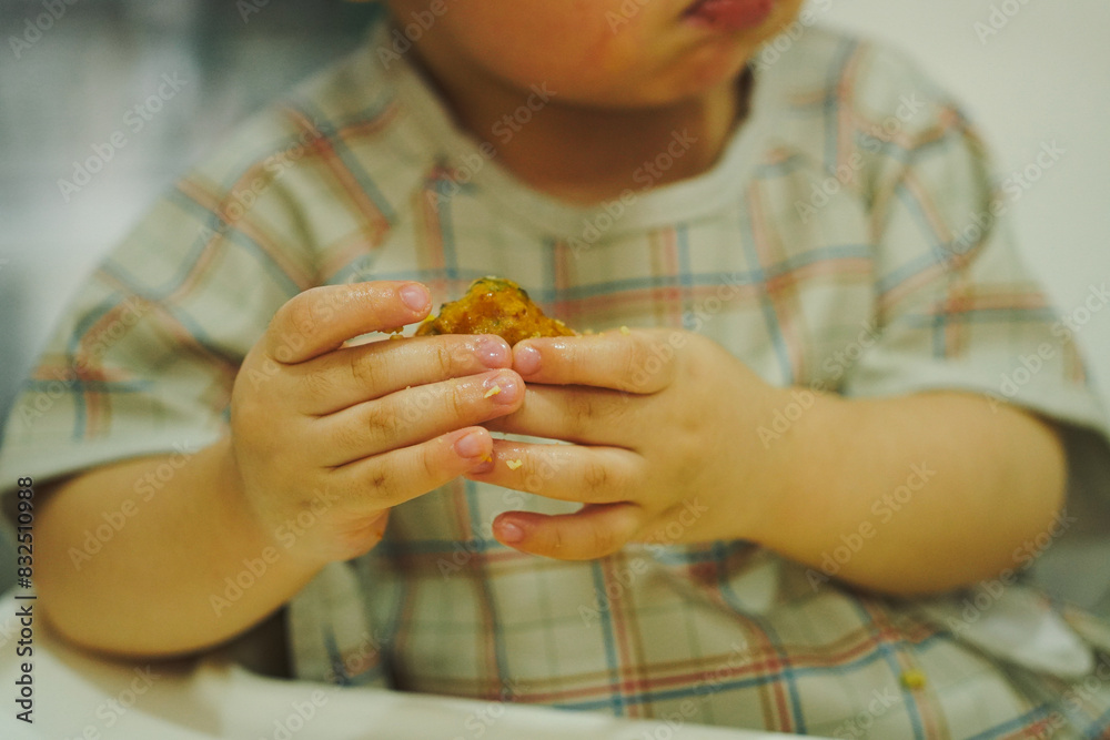 Close up of asian young boy holding food Close up of asian young boy holding food
