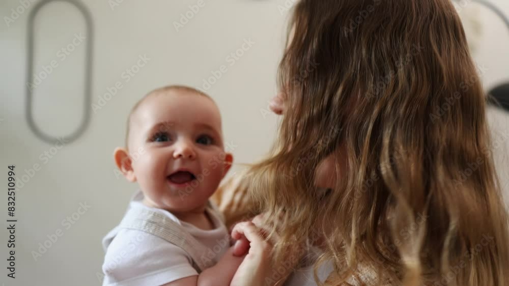 A young mom holds her little child and dances with her. The mother and child dance, laughing and smiling. A young mom holds her little child and dances with her. The mother and child dance, laughing and smiling.