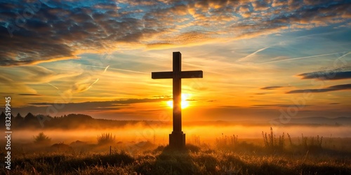 Silhouette of battlefield cross at sunrise with soft morning light photo
