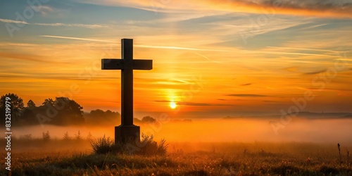 Silhouette of battlefield cross at sunrise with soft morning light photo