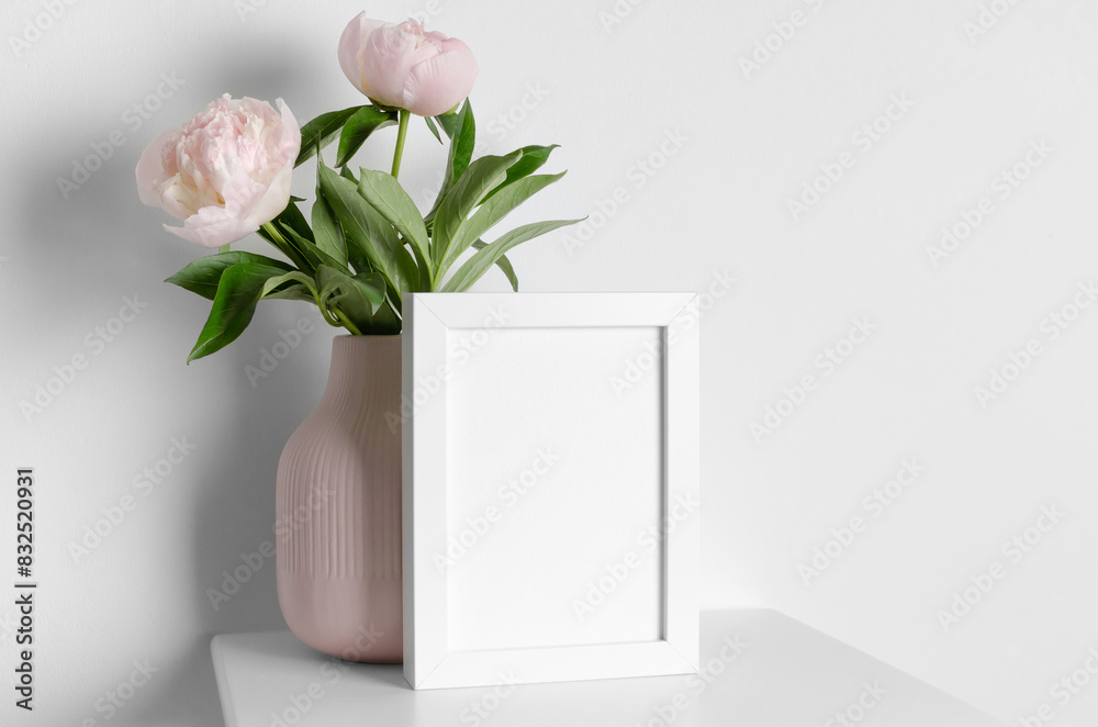Blank white frame mockup in minimalistic interior with peony flowers, frame mock up with copy space Blank white frame mockup in minimalistic interior with peony flowers, frame mock up with copy space