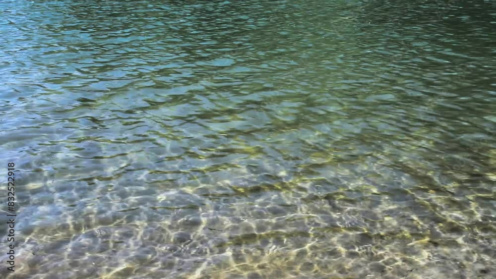 Surface of blue water. In the sunlight. Waves and sun reflection Surface of blue water. In the sunlight. Waves and sun reflection