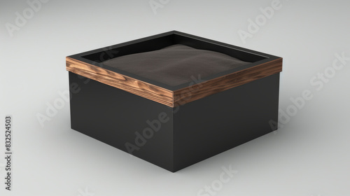 A modern, square packaging box with a black matte finish and a dark walnut wooden accent on the top, displayed in a trade show environment with sleek stands,