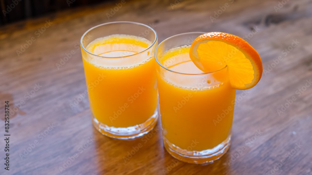 Glass of orange juice on food wooden table in restaurant cafe with orange Glass of orange juice on food wooden table in restaurant cafe with orange