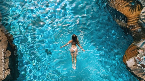 A woman wearing a bikini swims in a pool