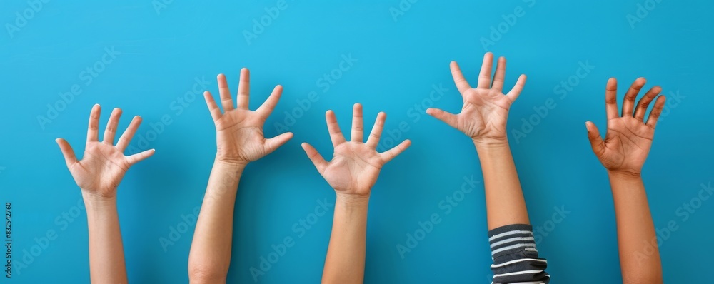 Many hands were raised in class, with a blue background Many hands were raised in class, with a blue background