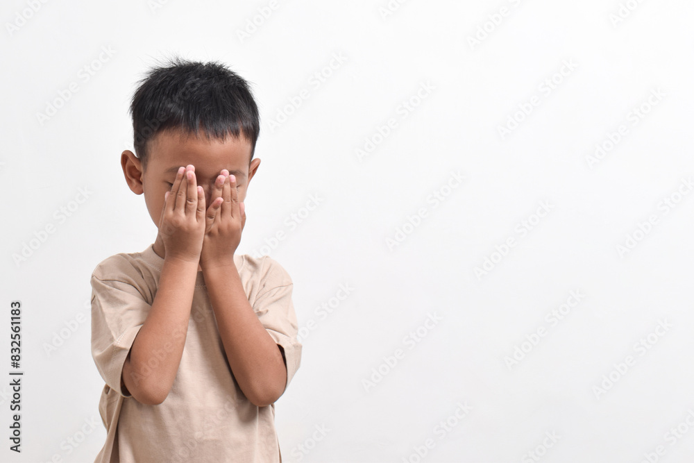 Image of Asian child posing with both hands covering his head on a white background. portrait of an Asian boy Image of Asian child posing with both hands covering his head on a white background. portrait of an Asian boy
