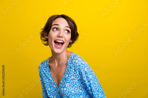 Photo of impressed girl with bob hairdo dressed print blouse staring at awesome sale empty space isolated on yellow color background