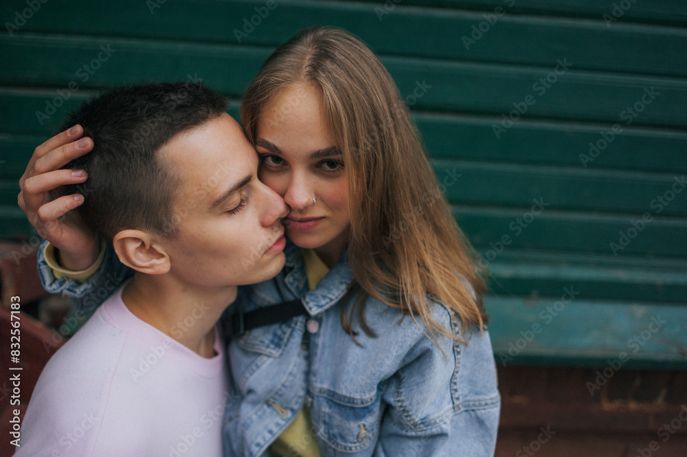 A happy young couple in love, a boy and a girl, on a walk in the city, hugging and walking. Urban European love story and photo shoot A happy young couple in love, a boy and a girl, on a walk in the city, hugging and walking. Urban European love story and photo shoot