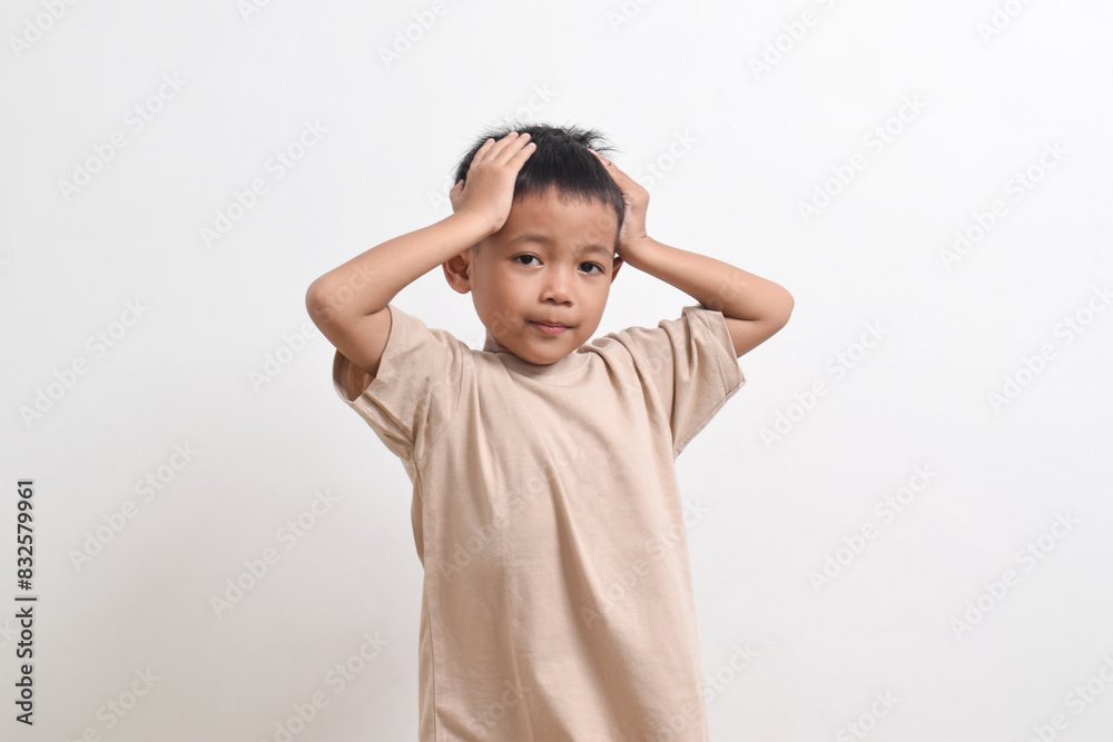 Image of Asian child pose holding head, headache concept on white background. portrait of an Asian boy Image of Asian child pose holding head, headache concept on white background. portrait of an Asian boy