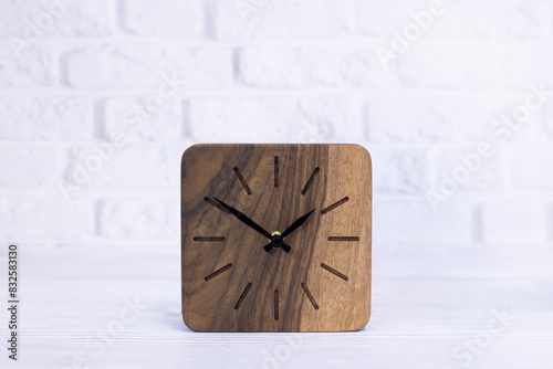 Clock made of wood. Square loft clock on a white background. Clock hands. Desktop