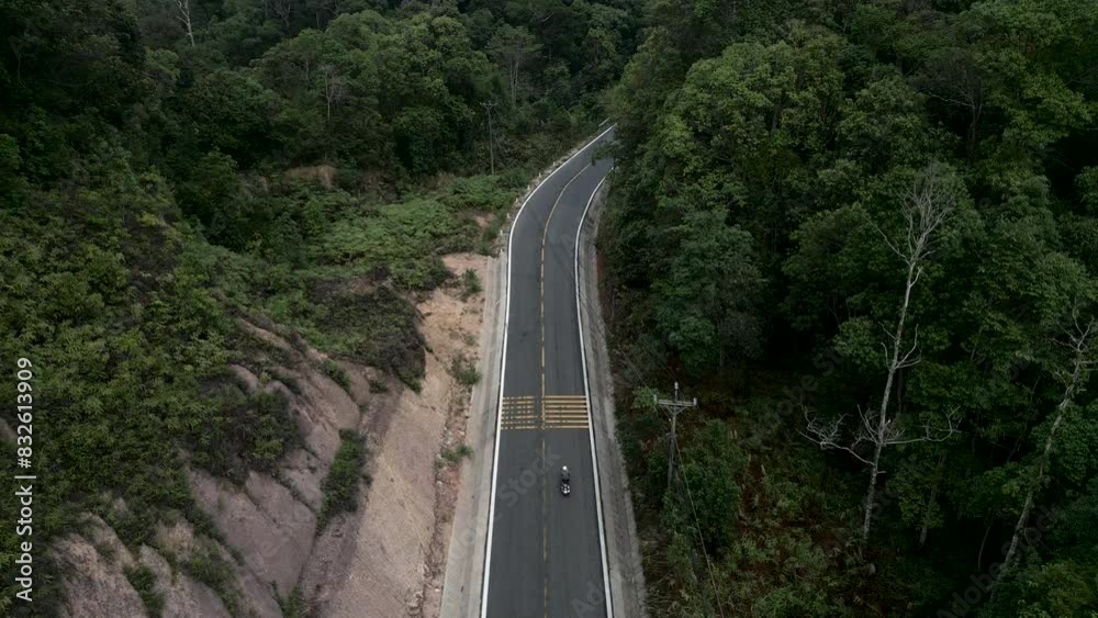 drone following the movements of a motorcycle that circulates on the road in the forest of Vietnam drone following the movements of a motorcycle that circulates on the road in the forest of Vietnam