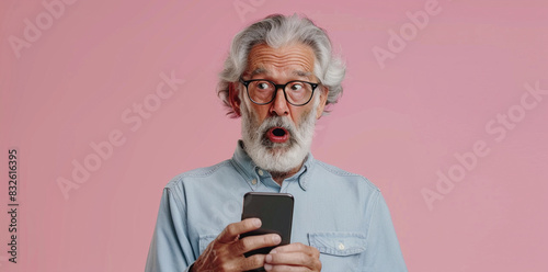 Surprised Elderly Man With Gray Hair Holding a Smartphone