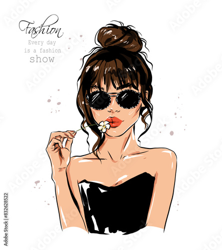Hand drawn beautiful young woman in sunglasses. Stylish girl with hair bun. Fashion woman holding flower. Sketch. Vector illustration.