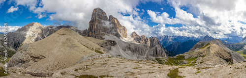 Panorama of the Dolomites mountains on a sunny day, blue sky with soe clouds. Beautiful mountians of Alpi Dolomiti in Italy, South Tirol alpine range in autumn