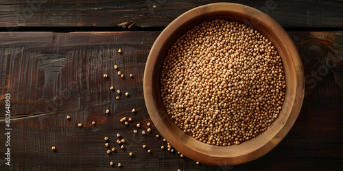  a wooden bowl filled with brown lentils. Surrounding the bowl are two smaller bowls, a cup, and a bulb of garlic background is a brown texture