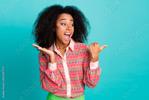 Photo of impressed positive woman wear print shirt showing thumb empty space isolated turquoise color background