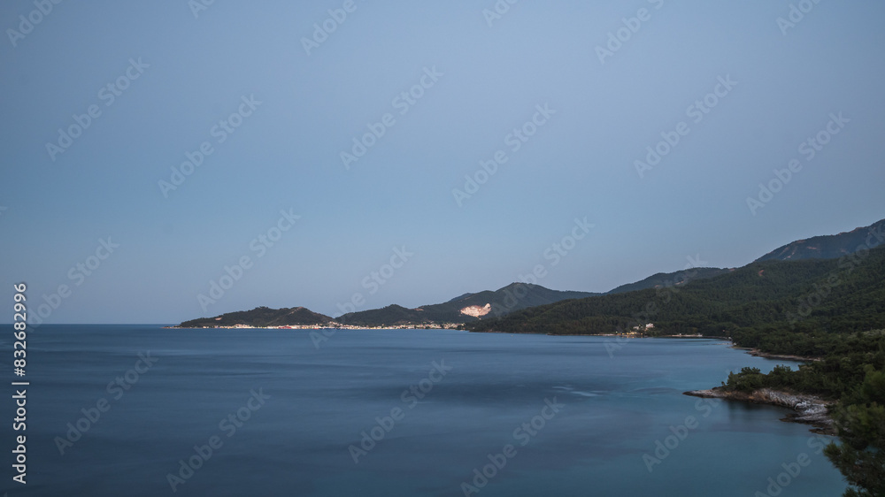 Fototapeta premium Distant view of the town of Limenas and the marble mine on the island of Thassos in the evening
