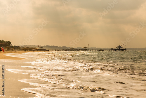 Fototapeta Naklejka Na Ścianę i Meble -  Sunrise along the coast of Antalya, Turkey, with the waves lapping at the shore and a jetty in the distance
