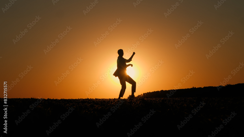 Silhouette of a woman playing air guitar at sunset Silhouette of a woman playing air guitar at sunset