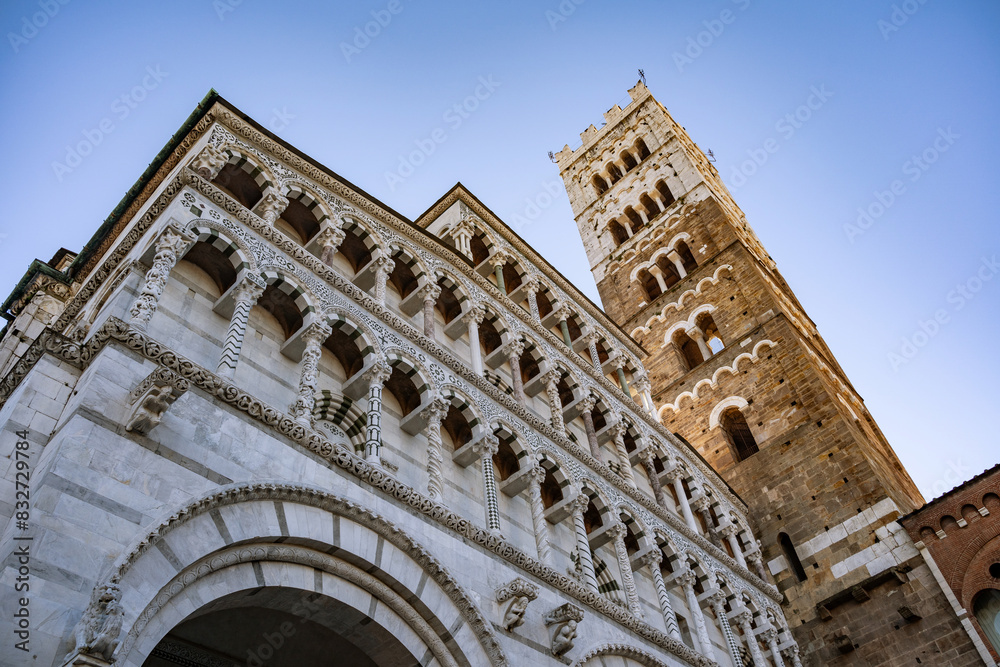 Fototapeta premium Romanesque Facade and bell tower of St. Martin Cathedral in Lucca, Tuscany. It contains most precious relic in Lucca, Holy Face of Lucca (Italian: Volto Santo di Lucca)
