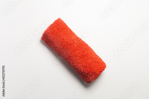 Fluffy orange-red rolled up towel on white background