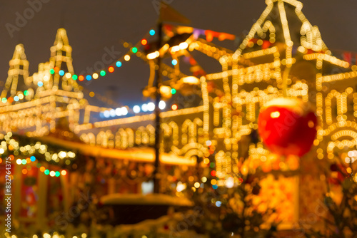 Defocused colorful houses on Christmas Fair in winter with lots of lights and bokeh on snowy evening