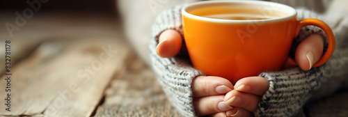 background of a woman's hands drinking a glass of hot tea on an autumn day