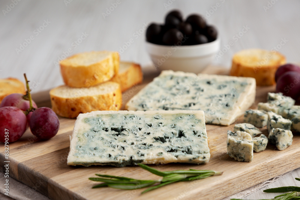 Organic Blue Cheese with Grapes and Olives on a Wooden Board, side view. Organic Blue Cheese with Grapes and Olives on a Wooden Board, side view.