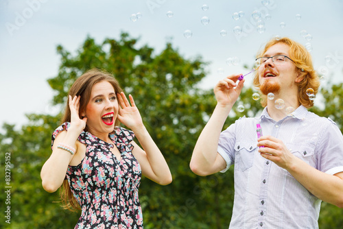 Couple blowing soap bubbles, having fun © Voyagerix