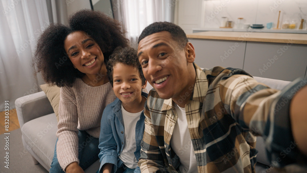 Happy family African American man woman male female parents little boy child kid son looking camera online phone smartphone mobile video call chat app talking waving hands gesture greeting indoor room Happy family African American man woman male female parents little boy child kid son looking camera online phone smartphone mobile video call chat app talking waving hands gesture greeting indoor room