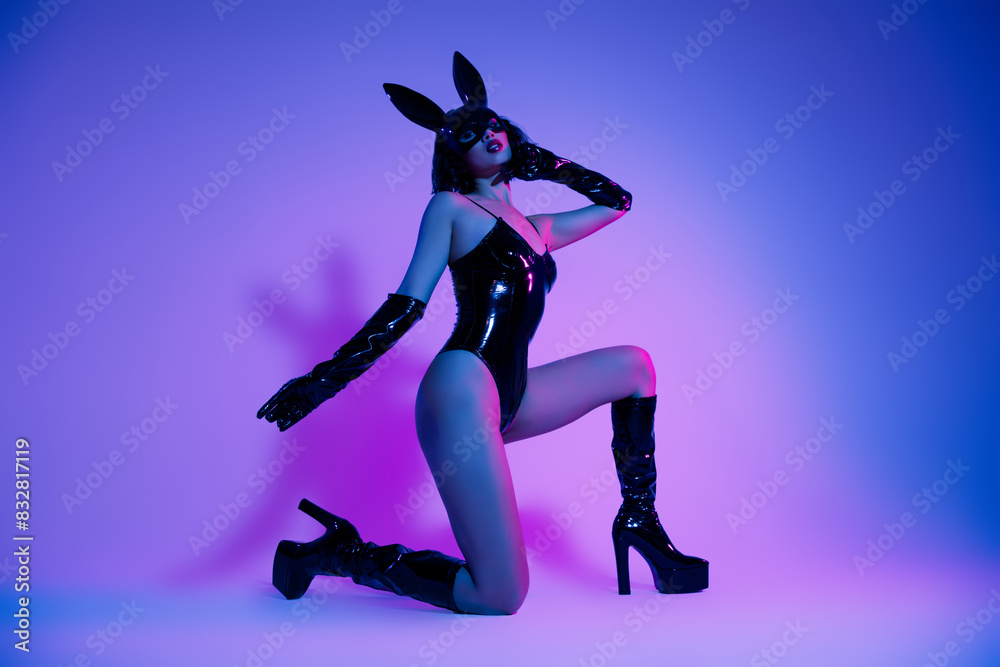 Photo of elegant girl in black leather rabbit bodysuit stand on knee feel passion isolated neon filter background Photo of elegant girl in black leather rabbit bodysuit stand on knee feel passion isolated neon filter background
