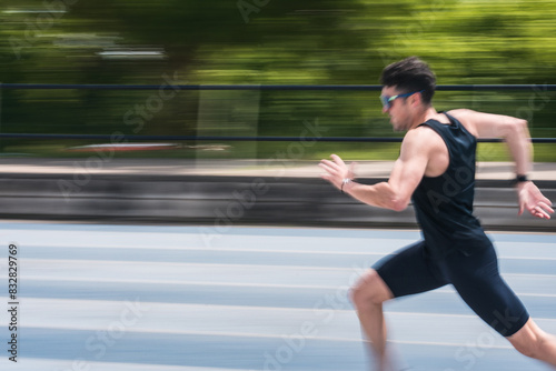 A man running on a track. The blurred background gives a feeling of high speed. © EJManzaneque