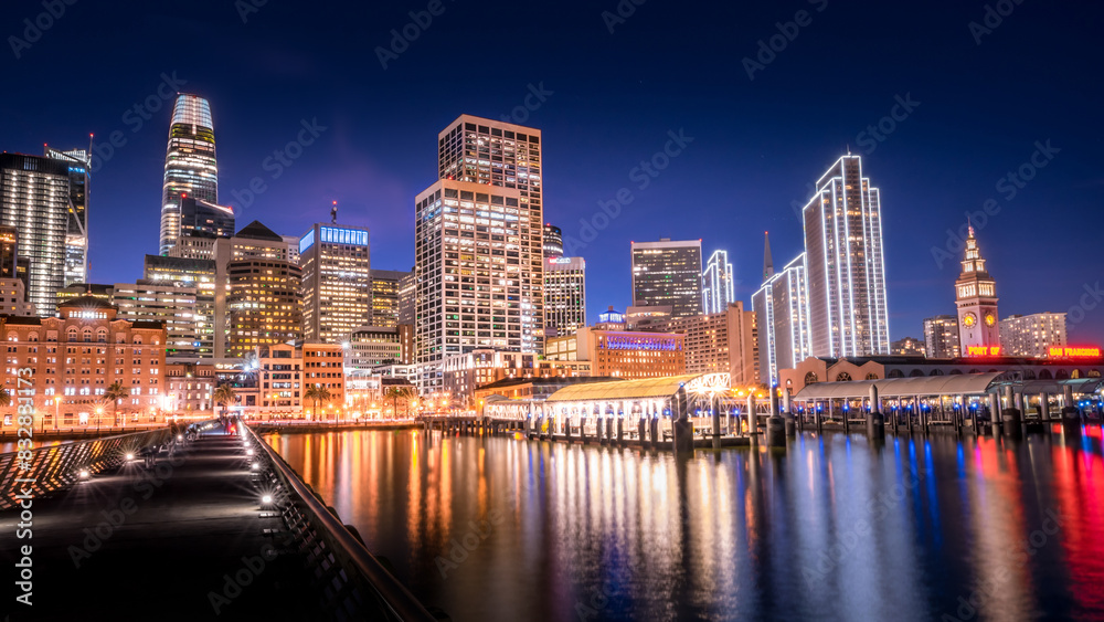Twilight cityscape with glowing skyscrapers and water reflections