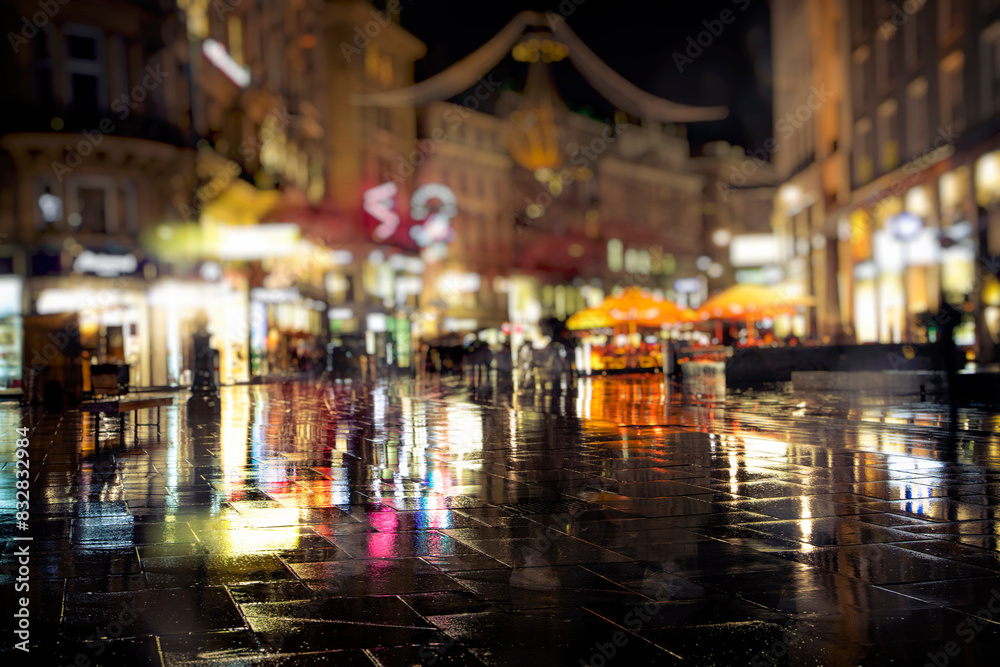 Rainy night on city street with glowing lights